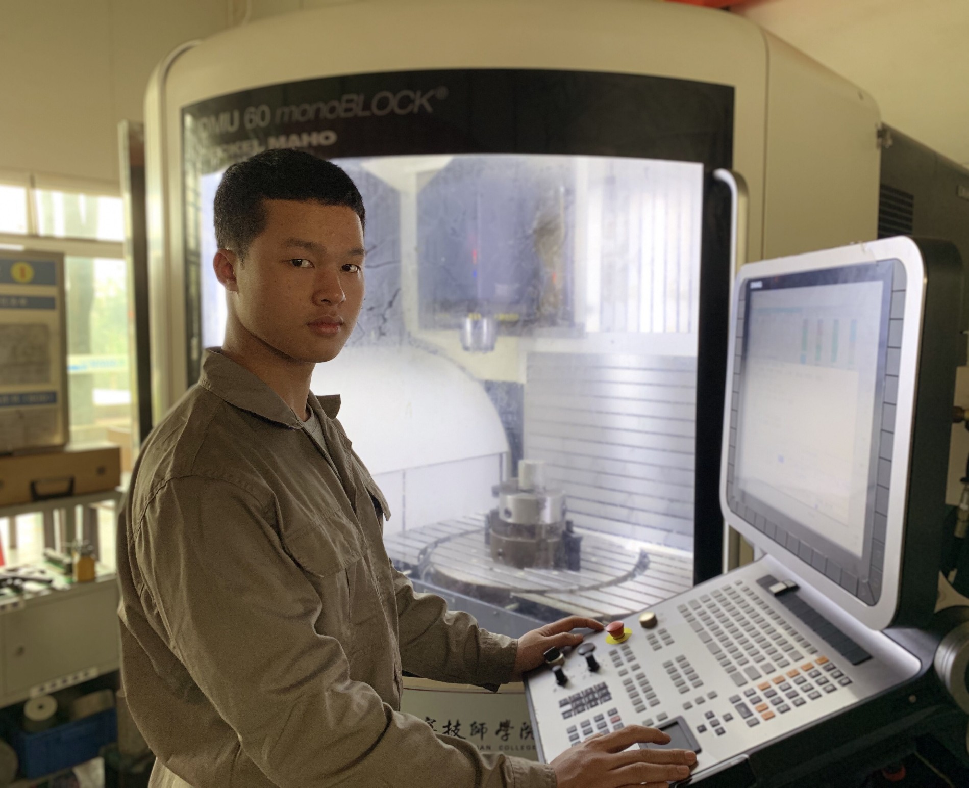 16级高模1班李有成同学操作五轴数控机床.jpg 16级高模1班李有成同学操作五轴数控机床.jpg